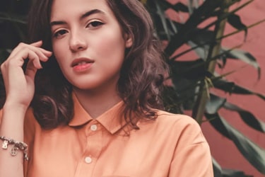 Woman in salmon shirt looking at the camera